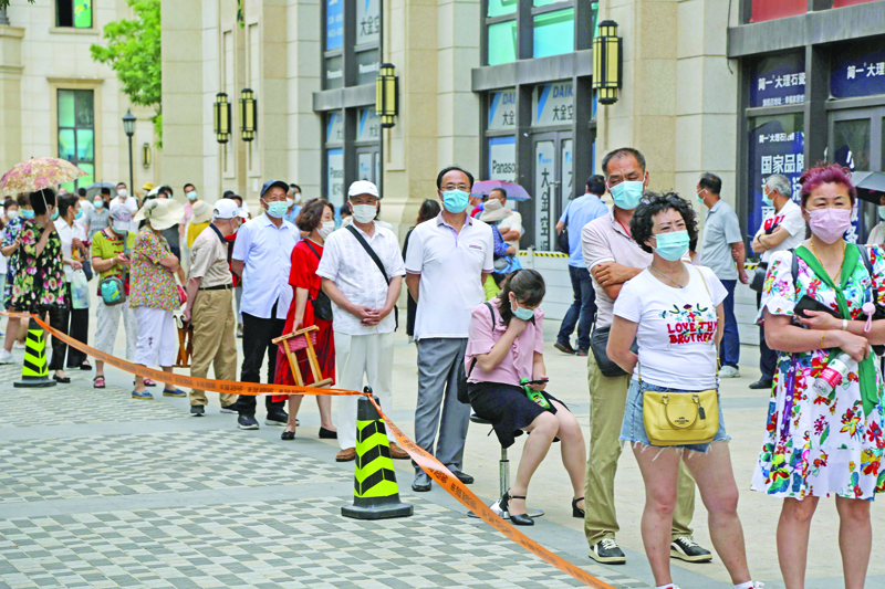 People line up to undergo COVID-19 coronavirus tests at a makeshift testing center in Dalian, in China's northeast Liaoning province on July 27, 2020. - China recorded 61 new coronavirus cases on July 27 -- the highest daily figure since April -- propelled by clusters in three separate regions that have sparked fears of a fresh wave. (Photo by STR / AFP) / China OUT
