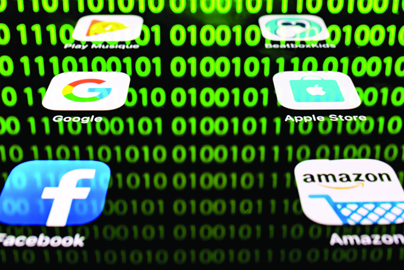 In this file illustration shows apps for Google, Amazon, Facebook, Apple (GAFA) and the reflection of a binary code displayed on a tablet screen.  Big Tech, its hands full with antitrust probes and complaints growing from activists and politicians, turns its attention to quarterly earnings in the coming days expected to show the growing power of Silicon Valley giants. — AFP