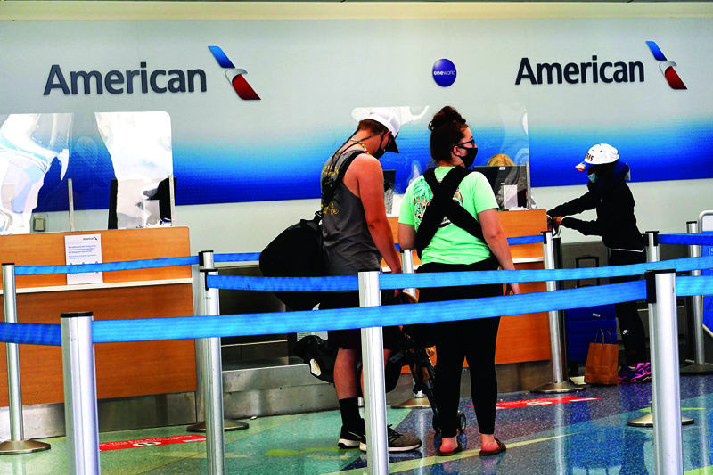 FORT LAUDERDALE, FLORIDA - JULY 16: People check in at the American Airlines counter in the Fort Lauderdale-Hollywood International Airport on July 16, 2020 in Fort Lauderdale, Florida. JetBlue Airways and American Airlines Group announced they will be creating an alliance between the two companies.   Joe Raedle/Getty Images/AFP