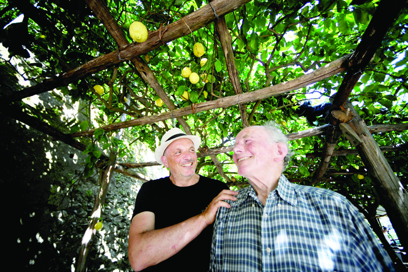 Salvatore and Gigino Aceto pose in their lemon tree farm, on July 2, 2020 in Amalfi. (Photo by Filippo MONTEFORTE / AFP)