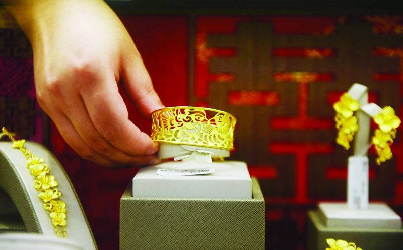 A staff member places gold jewellery in a display at a store in Hangzhou, in China's eastern Zhejiang province on July 27, 2020. - Gold hit a record high on July 27 as investors rushed into the safe-haven on concerns about China-US tensions, a spike in virus infections around the world and a lack of progress on a new stimulus bill in Washington. (Photo by STR / AFP) / China OUT