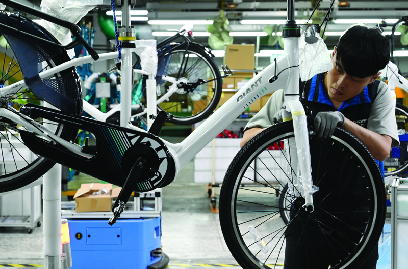 (FILES) In this file photo taken on May 21, 2019 a worker checks an e-bike at a factory of Giant -- the world's biggest bicycle manufacturer -- in Taichung. - After (Photo by Sam YEH / AFP)