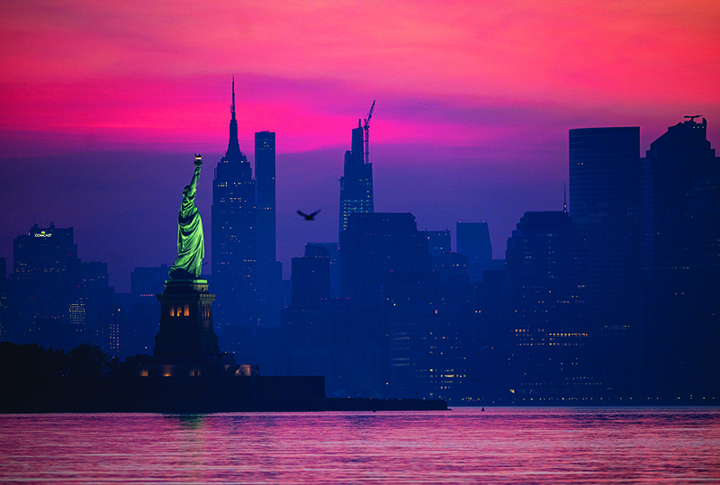NEW YORK: The Statue of Liberty is pictured in front of Lower Manhattan before sunrise amid the coronavirus pandemic on Sunday in New York City. — AFP