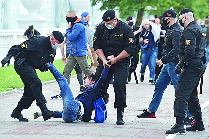 MINSK: Plainclothed Belarus’ security service agents and riot police officers detain a participant of a gathering of opposition supporters in Minsk. —AFP