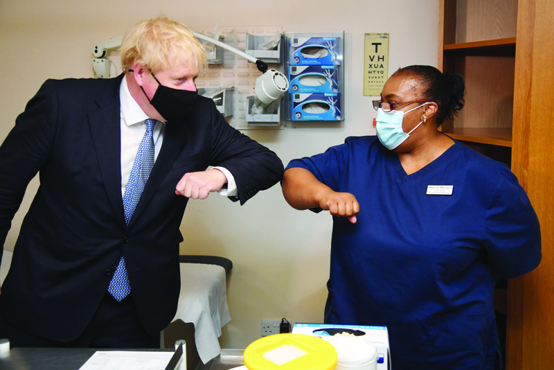Britain's Prime Minister Boris Johnson bumps elbows with a staff member during his visit to the Tollgate Medical Centre in Becton, east London on July 24, 2020.. (Photo by Jeremy Selwyn / POOL / AFP)