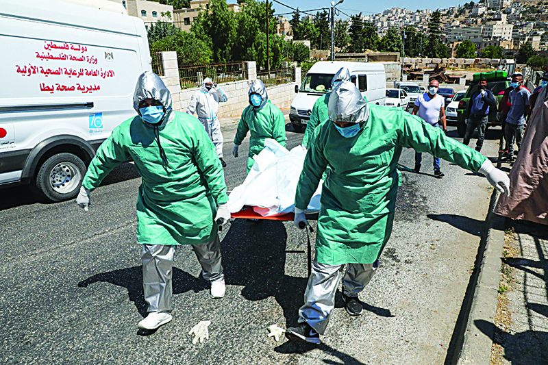 Staff of the Palestinian Ministry of Health in protective suits transport the body of 47-year-old Palestinian COVID-19 victim Nassra Abu Hussein for burial in the West Bank city of Hebron, on June 29, 2020. (Photo by HAZEM BADER / AFP)