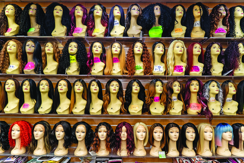 Wigs are pictured displayed for sale at a hair products shop in Peckham, south London on July 13, 2020, as novel coronavirus lockdown restrictions in England are further relaxed to allow nail bars, beauty salons and tattoo parlours to open. (Photo by Niklas HALLE'N / AFP)
