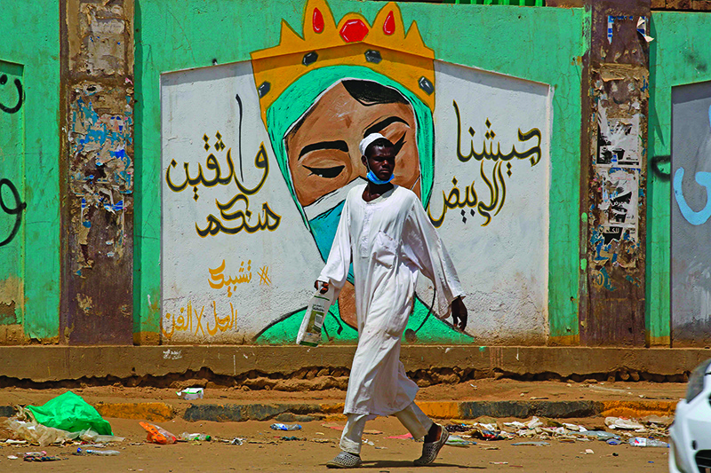 OMDOURMAN, Sudan: A man walks by a mural in the Sudanese capital Khartoum’s twin city on July 8, 2020. — AFP
