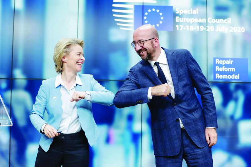 TOPSHOT - European Commission President Ursula Von Der Leyen (L) and European Council President Charles Michel (R) bump elbows at the end of the news conference following a four days European summit at the European Council in Brussels, Belgium, early July 21, 2020. - EU leaders approved a 750-billion-euro package to revive their coronavirus-ravaged economies after a tough 90-hour summit on July 21, along with a trillion-euro budget for the next seven years. (Photo by STEPHANIE LECOCQ / POOL / AFP)