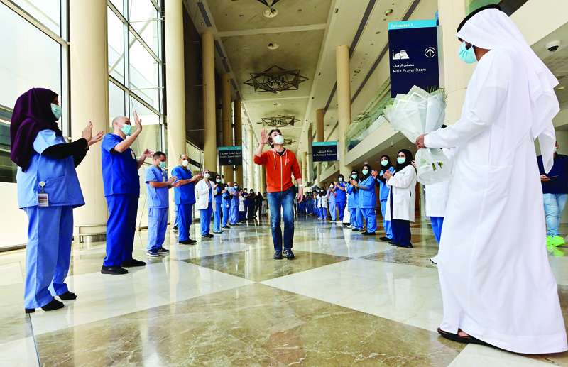 TOPSHOT - Hiroaki Fujita from Japan, the last patient at the temporary COVID-19 hospital built in downtown Dubai in the United Arabic Emirates, greets nurses and doctors as he leaves the facility, on July 7, 2020. (Photo by GIUSEPPE CACACE / AFP)