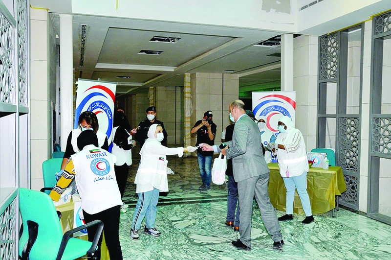 KUWAIT: Kuwait Red Crescent Society workers distributed face masks and hand sanitizers for employees working at Ministries Complex on Tuesday, following their return to work as Kuwait entered the second phase of easing restrictions imposed due to the spread of COVID-19.