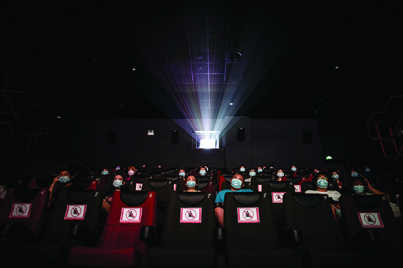 This photo taken on July 20, 2020 shows people watching a movie as they sit apart to ensure social distancing on the first day of the re-opening of cinemas since the COVID-19 coronavirus outbreak in Wuhan in China's central Hubei province. - Hundreds of cinemas reopened in scores of Chinese cities on July 20 after a six-month nationwide shutdown due to the coronavirus, highlighting its success in taming an epidemic still raging in parts of the world. (Photo by STR / AFP) / China OUT