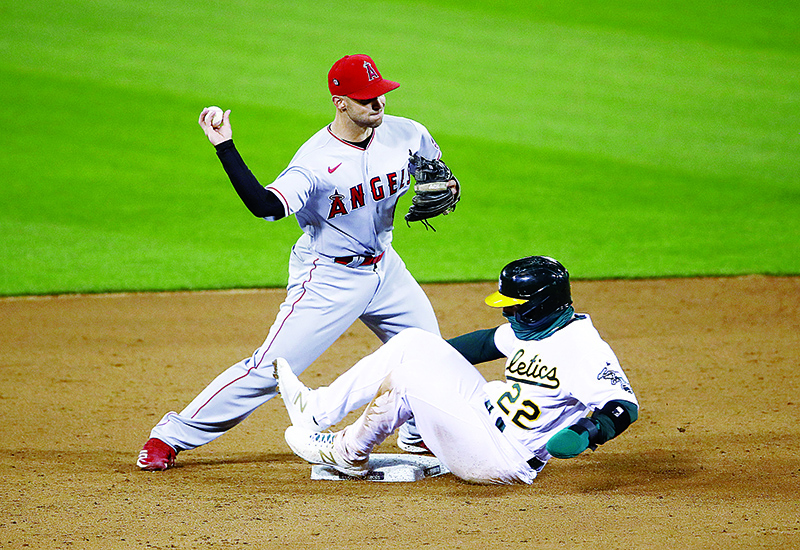 OAKLAND: Ramon Laureano #22 of the Oakland Athletics is forced out at second base as Tommy La Stella #9 of the Los Angeles Angels turns a double play in the sixth inning during opening day at Oakland-Alameda County Coliseum in Oakland, California. —AFP