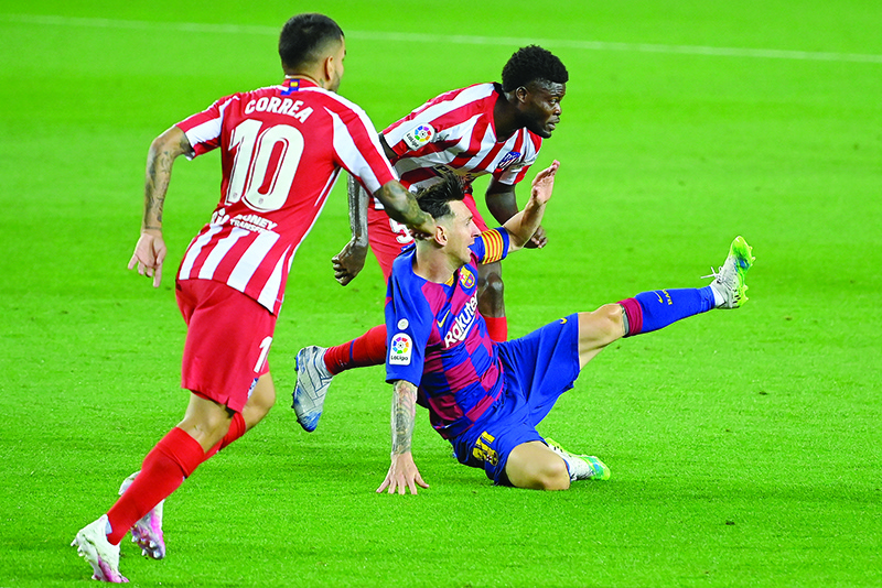 BARCELONA: Barcelona’s Argentine forward Lionel Messi (C) challenges Atletico Madrid’s Ghanaian midfielder Thomas Partey and Atletico Madrid’s Argentine forward Angel Correa (L) during the Spanish League football match between FC Barcelona and Club Atletico de Madrid at the Camp Nou stadium in Barcelona. — AFP