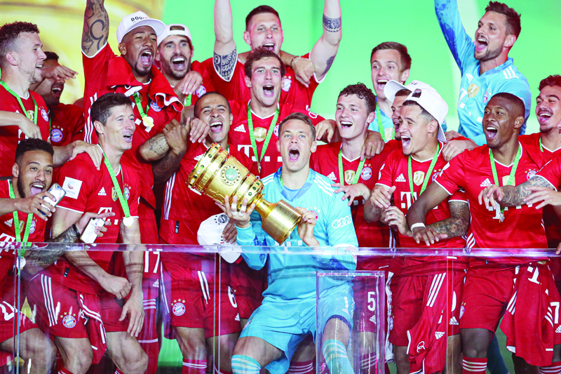 Bayern Munich's German goalkeeper Manuel Neuer raises the German Cup (DFB Pokal) trophy as he and his teammates celebrate winning the final football match Bayer 04 Leverkusen v FC Bayern Munich at the Olympic Stadium in Berlin on July 4, 2020. (Photo by Michael Sohn / POOL / AFP) / DFB REGULATIONS PROHIBIT ANY USE OF PHOTOGRAPHS AS IMAGE SEQUENCES AND QUASI-VIDEO.