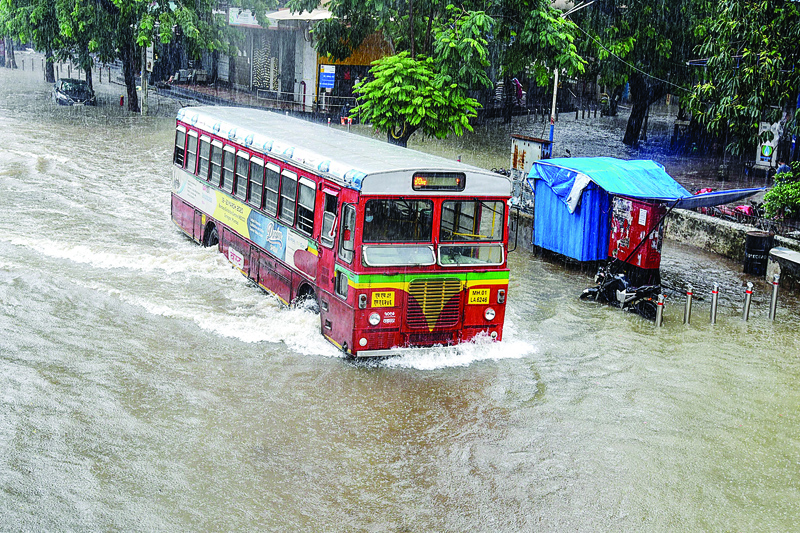 A bus makes its way through a flooded road during a rain shower in Mumbai on July 15, 2020. - The monsoon -- which usually falls from June to September -- is crucial to the economy of the Indian sub-continent, but also causes widespread death and destruction across the region each year. (Photo by Sujit JAISWAL / AFP)