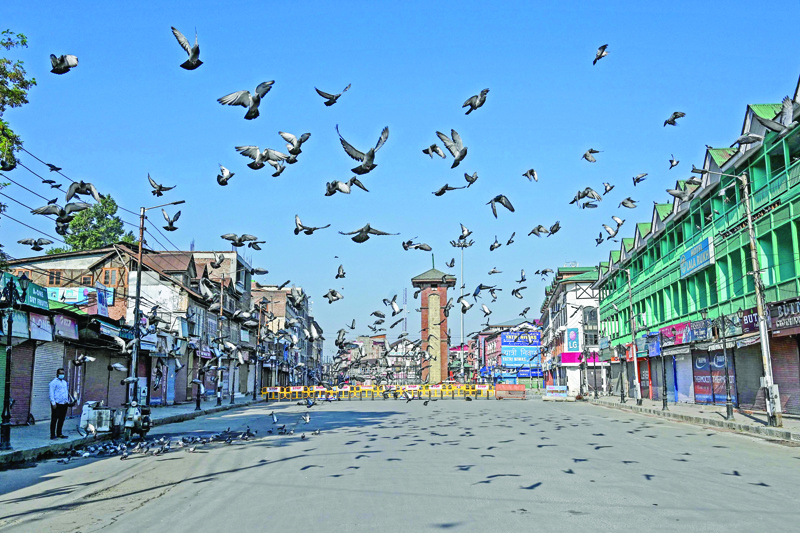 Pigeons take flight over an empty place during a lockdown imposed by the authorities as a preventive measure against the surge in COVID-19 coronavirus cases, in Srinagar on July 23, 2020. (Photo by TAUSEEF MUSTAFA / AFP)