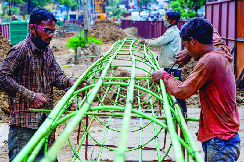 In this picture taken on July 22, 2020, migrant workers bind iron rods at a construction site in Mumbai. - Spurning free air tickets, accommodation and higher pay, millions of migrant workers who fled India's cities when the COVID-19 coronavirus hit are too scared to return, with grim implications for the already crumbling economy. (Photo by INDRANIL MUKHERJEE / AFP) / TO GO WITH Virus-health-India-economy-labour,FOCUS by Vishal Manve