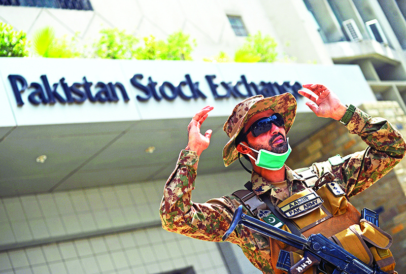 KARACHI: A paramilitary soldier gestures while standing guard outside the Pakistan Stock Exchange building a day after a gunmen attack in Karachi. — AFP
