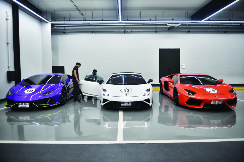 This photo taken on July 31, 2020 shows technicians inspecting a row of Lamborghini cars during a Lamborghini Club Thailand event at a showroom in Bangkok. - With tourism and exports in freefall, Thailand's growth could shrivel by as much as 10 percent this year, dumping millions into unemployment. But in a split-screen economy there are plenty with immunity to the economic scourge caused by COVID-19. (Photo by Lillian SUWANRUMPHA / AFP) / To go with 'THAILAND-ECONOMY-LUXURY-AUTOMOBILE,FOCUS' by Aidan JONES