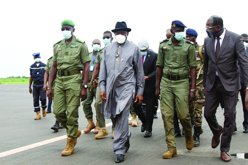 TOPSHOT - Former Nigerian President Goodluck Jonathan (2L) walks at the International Airport in Bamako upon his arrival on August 22, 2020 next to by Malick Diaw (L), the Vice President of the CNSP (National Committee for the Salvation of the People). - A delegation of West African leaders headed by former Nigerian president Goodluck Jonathan arrived in the Malian capital Bamako on August 22 on a mission to restore order after a military coup. (Photo by ANNIE RISEMBERG / AFP)