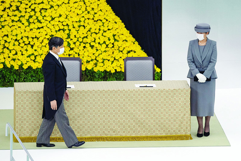 TOKYO: Japan’s Emperor Naruhito (left) and Empress Masako (right) wearing face masks, depart after attending a memorial service marking the 75th anniversary of Japan’s surrender in World War II at the Nippon Budokan hall in Tokyo yesterday.-AFP