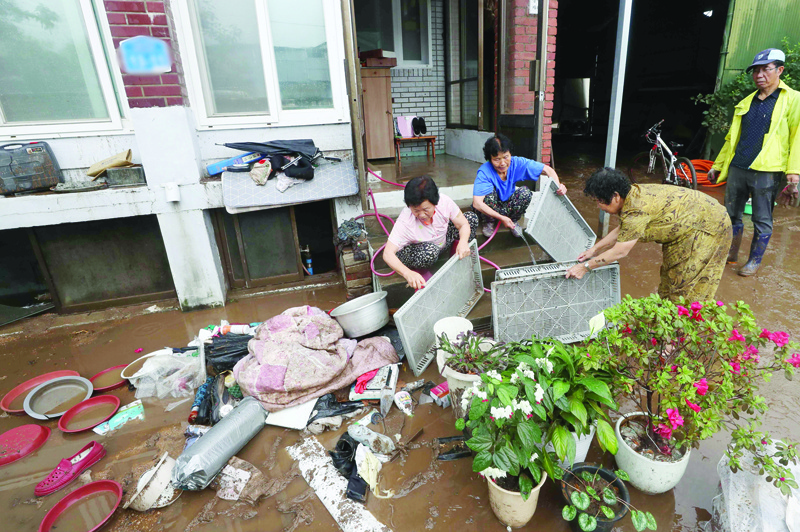 TOPSHOT - Residents clean debris from their home following heavy rain fall in Chorwon on August 6, 2020. (Photo by - / YONHAP / AFP) / - South Korea OUT / REPUBLIC OF KOREA OUT  NO ARCHIVES  RESTRICTED TO SUBSCRIPTION USE