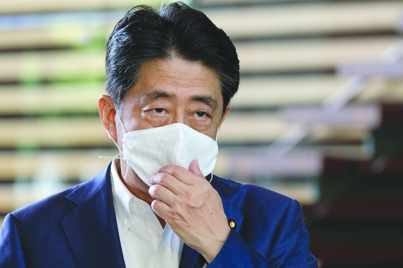Japan's Prime Minister Shinzo Abe wearing a face mask arrives at the Prime Minister's office in Tokyo on August 24, 2020. - Abe earlier in the day returned to hospital on August 24 for more medical checks, a government spokesman said, a week after a first visit that fuelled growing speculation about his health. (Photo by Kazuhiro NOGI / AFP)