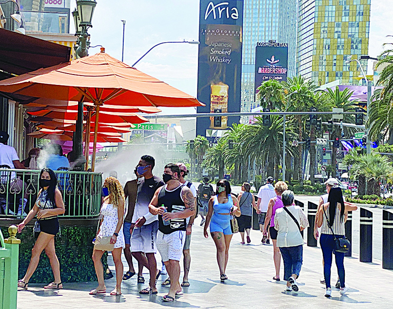 Tourists are wearing masks as they walk on the Strip in Las Vegas, Nevada, on August 28, 2020 amid the coronavirus pandemic. (Photo by Daniel SLIM / AFP)