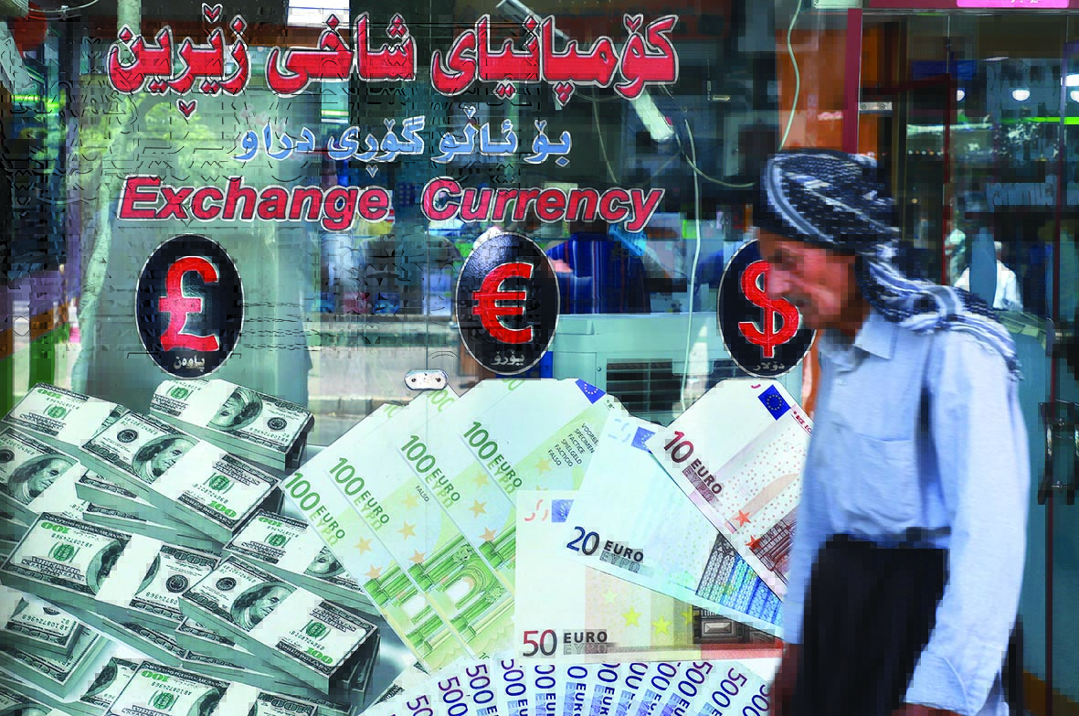 An Iraqi man walks past a money exchange office in Sulaimaniyah city in the Kurdish autonomous region of northern Iraq, on August 4, 2020. - In Iraq's Kurdistan and holy Shiite sites, trading US dollars for rials from Iran was once big business with millions of pilgrims and for businessmen coming to visit. But the money exchange business has been hard hit by lockdown restrictions to stop the spread of COVID-19. (Photo by Shwan MOHAMMED / AFP)
