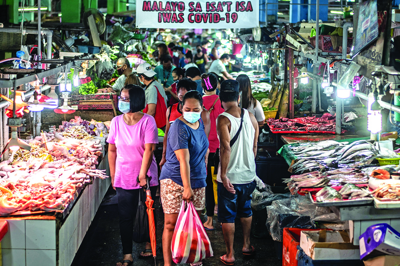 People wearing masks shop for fresh food at a market in Manila on August 6, 2020. - The Philippines plunged into recession after its biggest quarterly contraction in four decades, data showed on August 6, as the economy reels from COVID-19 coronavirus lockdowns that have wrecked businesses and thrown millions out of work. (Photo by Lisa Marie David / AFP)