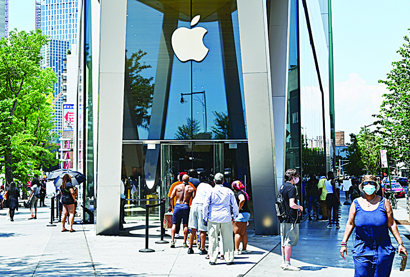 (FILES) In this file photo taken on June 22, 2020 People wait in line outside an Apple store on June 22, 2020 in the Brooklyn Borough of New York City. - Apple is on the verge of becoming the first $2 trillion company following a gravity-defying surge that has highlighted the value of its iPhone ecosystem during the global pandemic.nShares in Apple have roughly doubled from late March lows, an astonishing performance which has lifted chief executive Tim Cook's net worth to $1 billion, according to the Bloomberg Billionaires Index calculation. Apple's market value based on its share price was just above $1.9 trillion on Tuesday, well ahead of Big Tech peers Amazon ($1.56 trillion) Microsoft  ($1.55 trillion) and Google parent Alphabet ($1.01 trillion). (Photo by Angela Weiss / AFP)