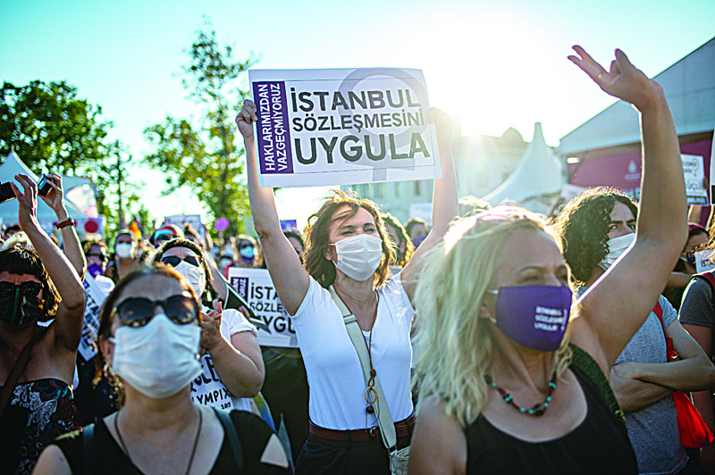 Demonstrators wearing protective face masks hold up placards during a demonstration for a better implementation of the Istanbul Convention and the Turkish Law 6284 for the protection of the family and prevention of violence against women, in Istanbul, Turkey, on August 5, 2020. - Thousands of women in Turkey took to the streets on August 5 to demand that the government does not withdraw from a landmark treaty on preventing domestic violence. (Photo by Yasin AKGUL / AFP)