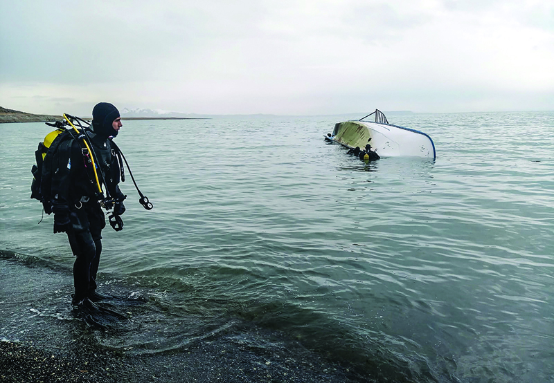 (FILES) In this file photo taken on December 26, 2019, a rescue diver stands on the shores of Lake Van after a boat carrying refugees and migrants sank in eastern Turkey as seven migrants were killed after their boat sank in Lake Van in eastern Turkey. - Europe in  2015 suffered its worst refugee crisis since World War II, when over one million people fled to the continent. (Photo by - / DHA / AFP) / Turkey OUT