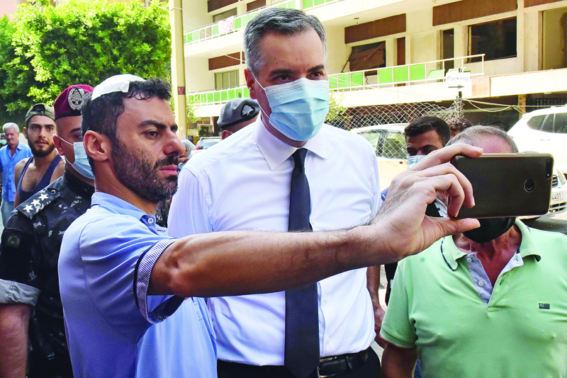 A wounded man takes a picture with the newly-appointed Prime Minister Mustapha Adib during his tour in Beirut's badly-hit Gemmayzeh neighbourhood, on August 31, 2020. - Lebanon's under-fire political leaders designated a new prime minister, the diplomat Mustapha Adib, to tackle the country's deep political and economic crisis, hours before French President Emmanuel Macron was due to visit. (Photo by - / AFP)