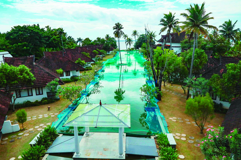 In this picture taken on August 23, 2020, a general view of a swimming pool that has been turned into a fish farm is pictured at Aveda Resort in Kumarakom, in Kerala state. - A luxury resort in southern India has turned its swimming pool into a fish farm to stop the business sinking amid the pandemic economic crisis. Normally the 150 metre (500 feet) long swimming pool at the Aveda Resort in Kerala state is packed with European tourists. Now thousands of pearl spot fish are causing the splash. (Photo by Arun CHANDRABOSE / AFP)