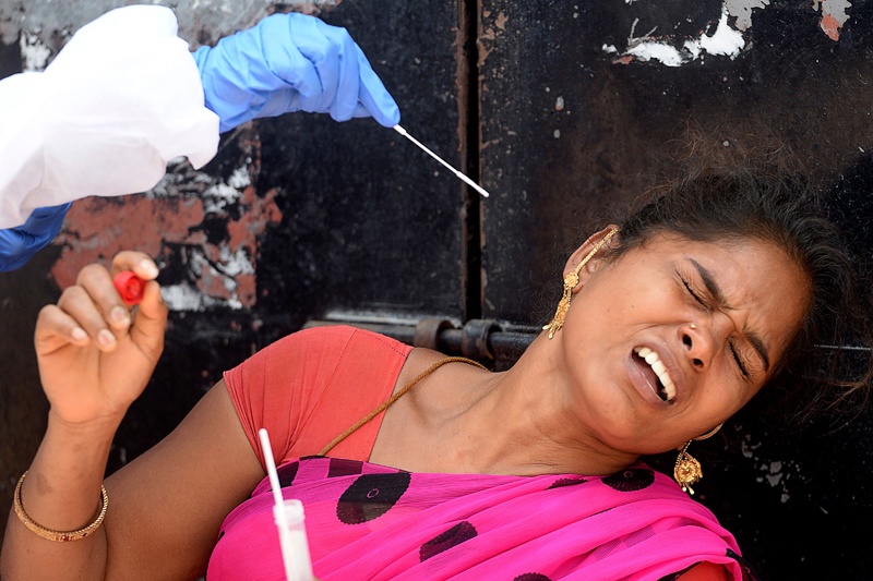 A health worker takes a swab sample from a woman to test for the Covid-19 coronavirus at a testing camp in a residential area, in Chennai on August 30, 2020. - India on August 30 set a coronavirus record when it reported 78,761 new infections in 24 hours -- the world's highest single-day rise -- even as it continued to open up the economy. (Photo by Arun SANKAR / AFP)