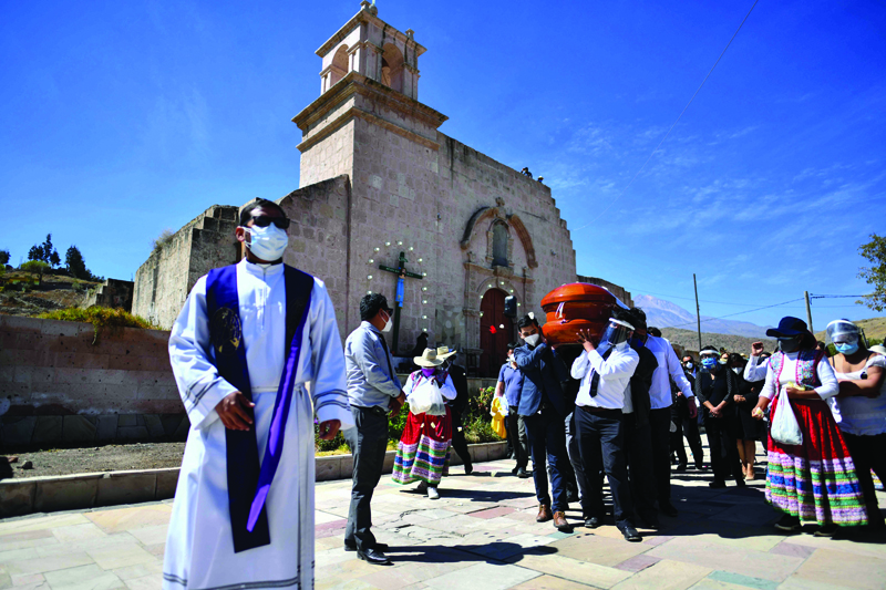 Residents of the rural community of Yura, close to the city of Arequipa, in southern Peru, participate in the burial of their mayor Angel Benavente, with an outdoor mass and an animated funeral possession on August 14, 2020, during which neighbors and musicians bade farewell to their head authority who died of COVID19. - Peru is one of worst hit countries in coronavirus-epicenter Latin America after Brazil and Mexico, with more than 25,000 reported deaths and over half a million cases. (Photo by Diego Ramos / AFP)