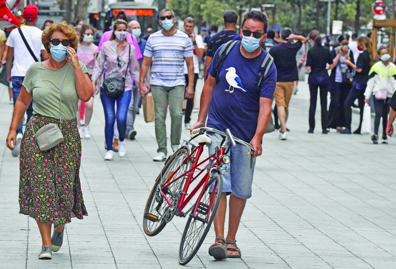 People with protective mask walk on a pedestrian street in Lyon on August 22, 2020 on the first day of mandatory mask wearing in parts of city centre. - Masks are obligatory to curb the spread of COVID-19 disease caused by the novel coronavirus in France in open areas of some cities as well as on public transport and in enclosed spaces such as shops, banks and government offices. (Photo by PHILIPPE DESMAZES / AFP)