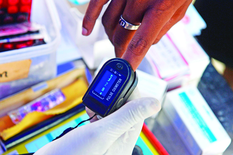 A health worker checks the oxygen saturation level of a woman using a pulse oximeter at a Covid-19 coronavirus testing camp in a residential area, in Chennai on August 30, 2020. - India on August 30 set a coronavirus record when it reported 78,761 new infections in 24 hours -- the world's highest single-day rise -- even as it continued to open up the economy. (Photo by Arun SANKAR / AFP)