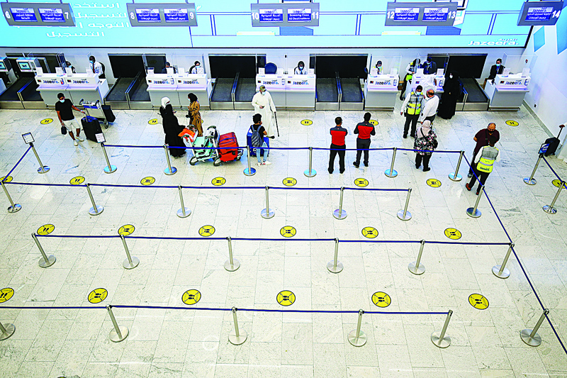 Travellers arrive at Kuwait international Airport, in Farwaniya, about 15kms south of Kuwait City, on August 1, 2020. - Commercial flights resumed at Kuwait International Airport today after months of shut down due to the COVID-19 pandemic. (Photo by YASSER AL-ZAYYAT / AFP)