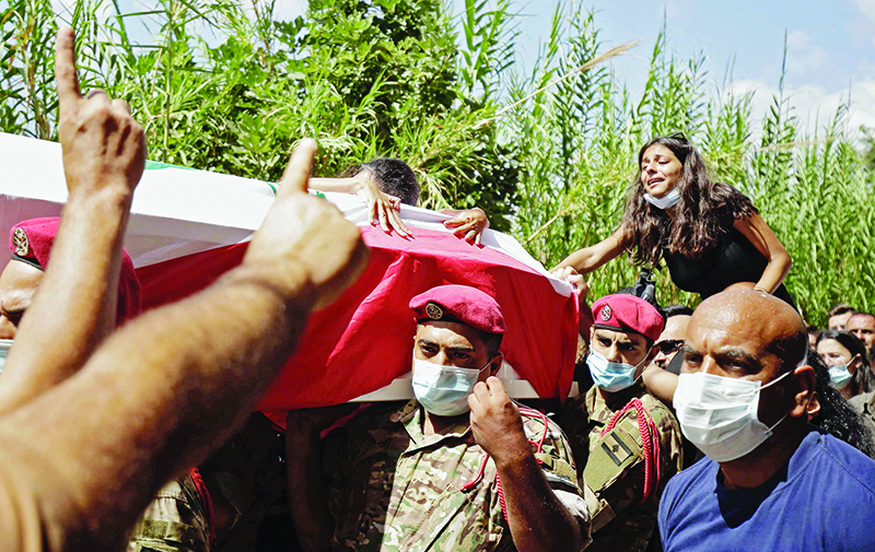 A woman mourns during a funerary procession for Lebanese army corporal Estephan Rouhana at his hometown of Batroun in northern Lebanon on August 10, 2020, after he died in the August 4 massive blast at the port of Beirut. - According to Lebanon's health ministry, over 150 people were killed by the huge chemical explosion that hit the capital's port in the country's worst peacetime disaster, while 6,000 were wounded and around 20 remained missing, leaving behind a 43-metre (141 foot) deep crater at the site. (Photo by Ibrahim CHALHOUB / AFP)