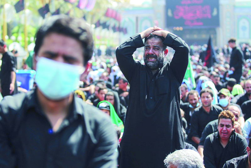 Iraqi Shiite Muslims cry as they take part in a mourning ritual on the tenth day of the month of Muharram which marks the peak of Ashura, amid the COVID-19 pandemic, in the holy city of Karbala, on August 30, 2020. - Ashura is a period of mourning in remembrance of the seventh-century martyrdom Imam Hussein, who was killed in the battle of Karbala in modern-day Iraq, in 680 AD. (Photo by AHMAD AL-RUBAYE / AFP)