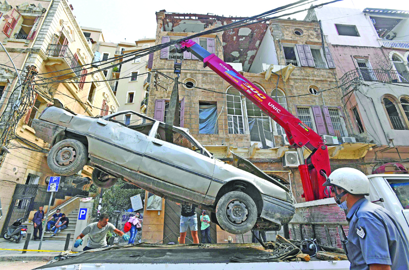 The wreckage of a car is removed from Beirut's Gemmayzeh neighbourhood on August 17, 2020, following a cataclysmic explosion that ripped through large parts of Lebanon's capital. - The August 4 explosion was caused by hazardous material left unsecured at the port for years, despite warnings over its danger, a fact that further enraged Lebanese who already saw the political class as incompetent and corrupt. (Photo by - / AFP)