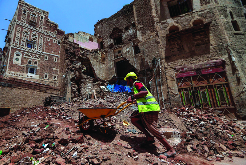 Yemeni labourers remove the rubble ahead of restoration works on the site of a collapsed UNESCO-listed building following heavy rains, in the old city of the Yemeni capital Sanaa, on August 12, 2020. - Flash floods triggered by torrential rains have killed at least 172 people across Yemen over the past month, damaging homes and UNESCO-listed world heritage sites, officials said. (Photo by Mohammed HUWAIS / AFP)