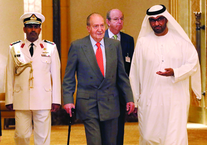(FILES) In this file photo taken on April 14, 2014 Spain's King Juan Carlos (C) is welcomed by State Minister and chief executive officer of the Abu Dhabi Future Energy Company (Masdar), Sultan Ahmed al-Jaber upon his arrival for a session of the first UAE-Spain Economic Forum at the Emirates Palace hotel in Abu Dhabi, United Arab Emirates. - The Spanish king emeritus Juan Carlos I, who went into exile persecuted by a corruption scandal two weeks ago, is in the United Arab Emirates, the Royal House announced on August 17, 2020, clearing up the unknown about the whereabouts of the former head of state. (Photo by Karim SAHIB / AFP)