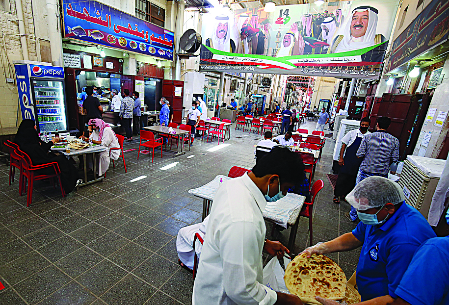 People have lunch at a restaurant in Kuwait City on August 18, 2020, as businesses such as barbershops, beauty salons, gyms and spas, reopen after a 5-month shutdown due to the spread of the novel coronavirus (COVID-19). (Photo by YASSER AL-ZAYYAT / AFP)