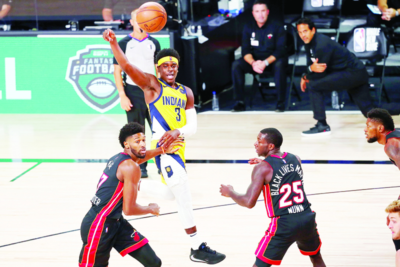 LAKE BUENA VISTA:  Aaron Holiday #3 of the Indiana Pacers passes the ball against Kyle Alexander #17 and Kendrick Nunn #25 of the Miami Heat during the second half of a NBA basketball game at AdventHealth Arena at ESPN Wide World Of Sports Complex in Lake Buena Vista, Florida. — AFP