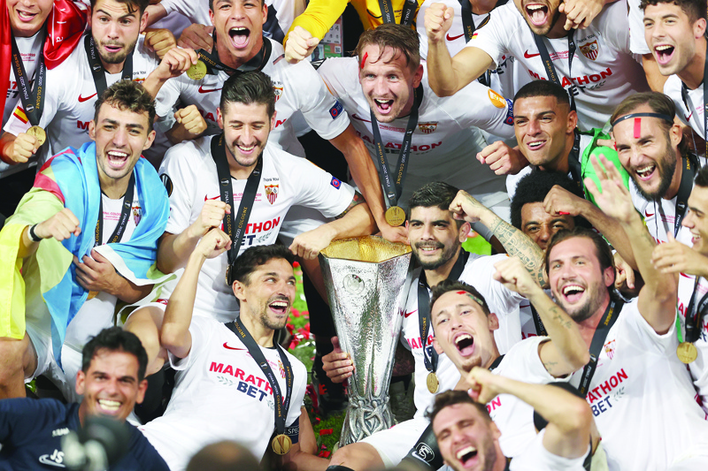 Sevilla's players celebrate with the trophy after winning the UEFA Europa League final football match Sevilla v Inter Milan on August 21, 2020, in Cologne, western Germany. (Photo by Lars Baron / POOL / AFP)