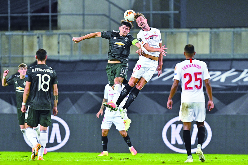 Manchester United's English defender Harry Maguire and Sevilla's Dutch forward Luuk De Jong  both jump to head the ball during the UEFA Europa League semi-final football match Sevilla v Manchester United on August 16, 2020 in Cologne, western Germany. (Photo by Martin Meissner / POOL / AFP)
